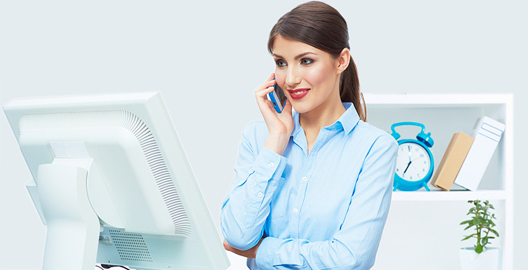 Female receptionist using a phone and computer